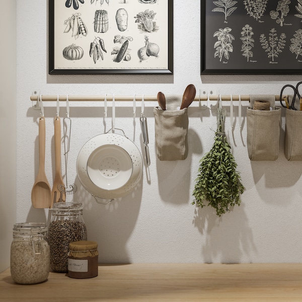 两个KNOPPANG框架海报和NEREBY桦树rails在白色的墙上,悬挂厨房用具和容器。