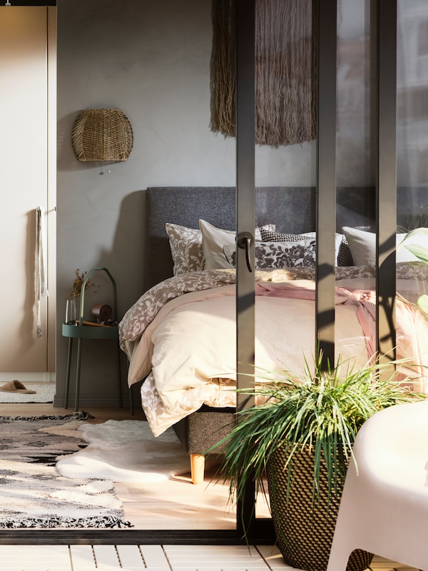 Un宿舍însorit cu o combinawie de dulap PAX/REINSVOLL lângă Un pat IDANÄS acoperit cu o lenjerie de pat uni/ floralova。