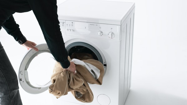 我们虽然锄iemands armen, gehuld兰格zwarte mouwen, lichtbruin textiel在即使wasmachine stoppen。